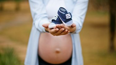 zwangere vrouw met babyschoentjes