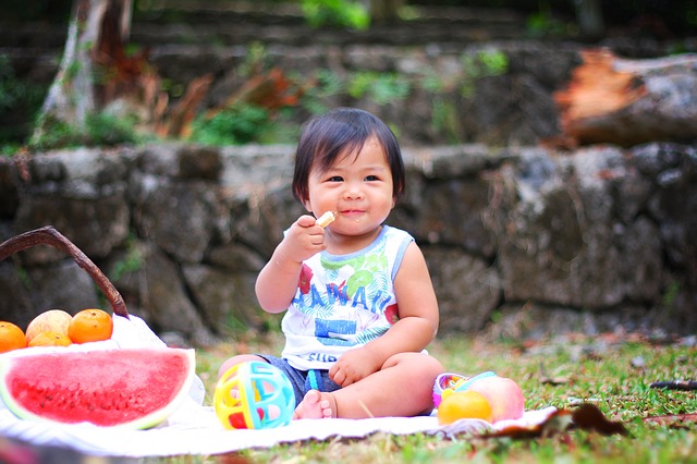 kind eet fruit bij picknick