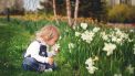 kind ruikt aan bloem