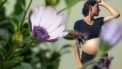 zwangere vrouw achter bloem