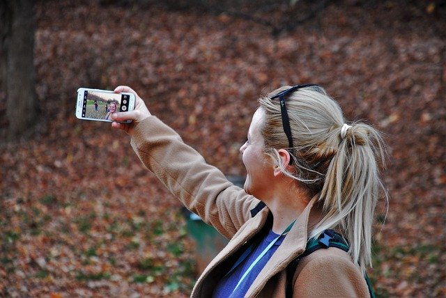 vrouw maakt selfie in het bos
